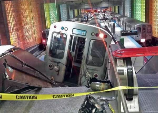 A Chicago Transit Authority train car rests on an escalator at the O'Hare Airport station after derailing. Picture: AP