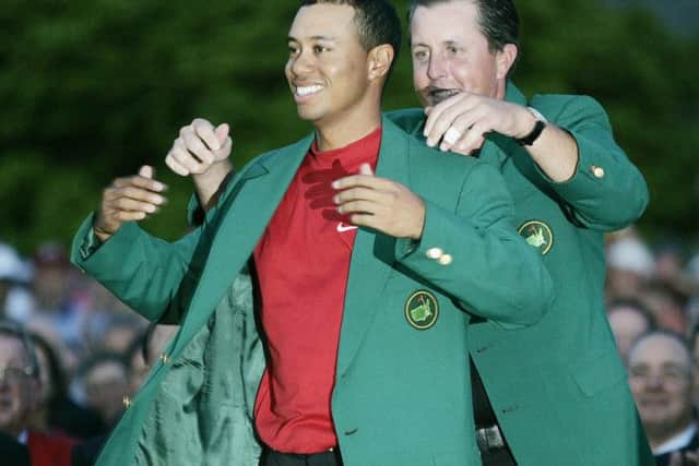 Tiger Woods, left, gets the Green Jacket from Phil Mickelson in 2005. Picture: AP