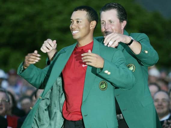 Tiger Woods, left, gets the Green Jacket from Phil Mickelson in 2005. Picture: AP