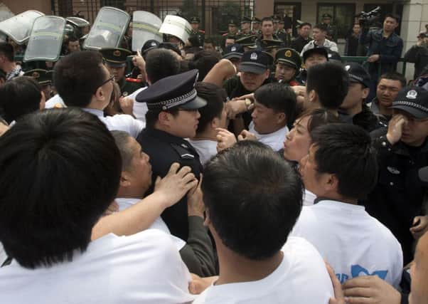 Relatives of Chinese passengers onboard the Malaysia Airlines plane MH370 scuffle with Chinese police officers during protests outside the Malaysian embassy in Beijing. Picture: AP Photo/Ng Han Guan