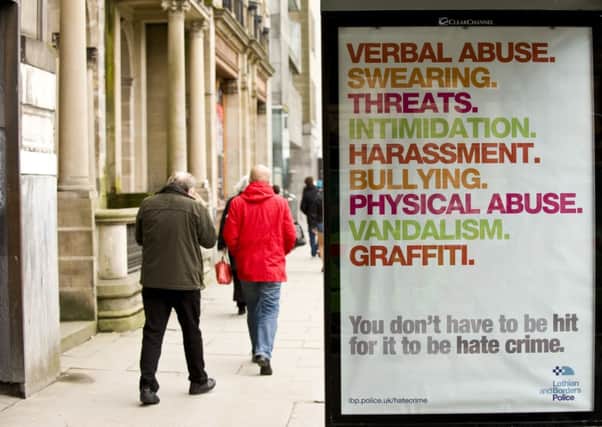 Pedestrians walk past an anti-hate crime poster in Edinburgh. Picture: Ian Georgeson