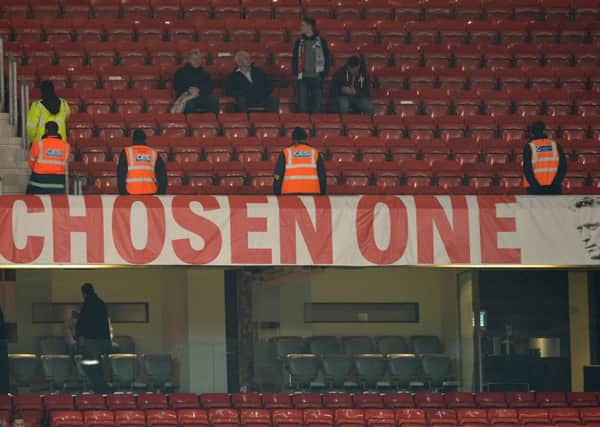 Stewards stand by the banner depicting Manchester United manager David Moyes. Picture: Getty