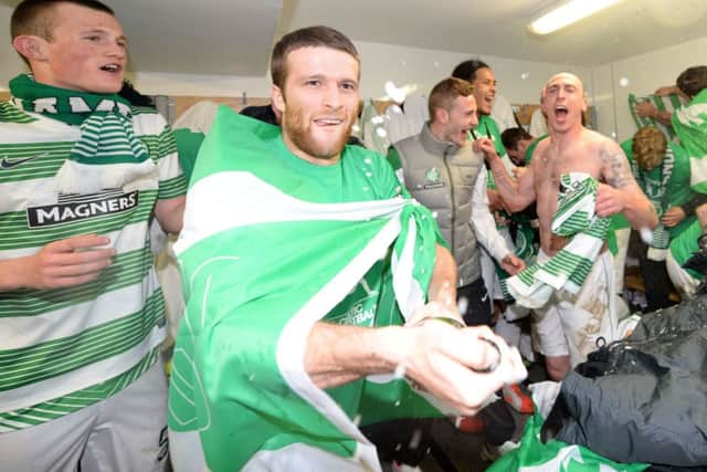 Adam Matthews cracks open the bubbly in the Celtic dressing room. Picture: SNS