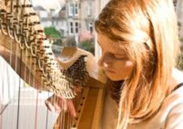 Harpist Fiona Rutherford creates harmony with two disabled musicians. Picture: Contributed