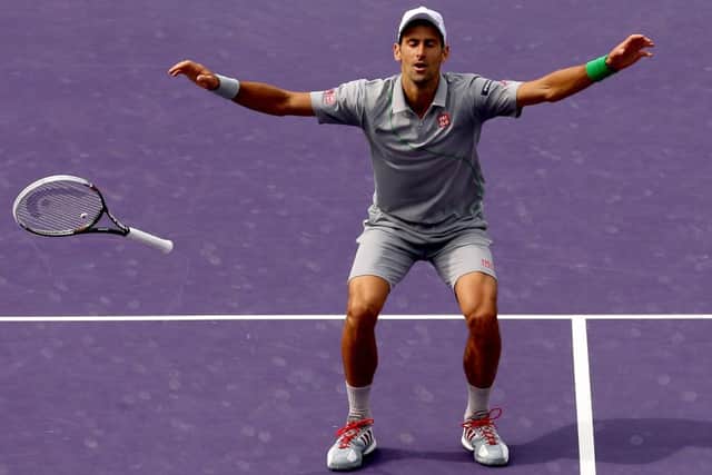 Novak Djokovic drops his racket in celebration. Picture: Getty