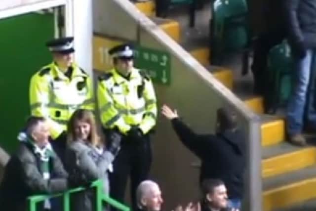 The Celtic fan dances as the Police officers look on. Picture: Youtube