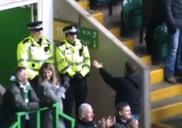 The Celtic fan dances as the Police officers look on. Picture: Youtube