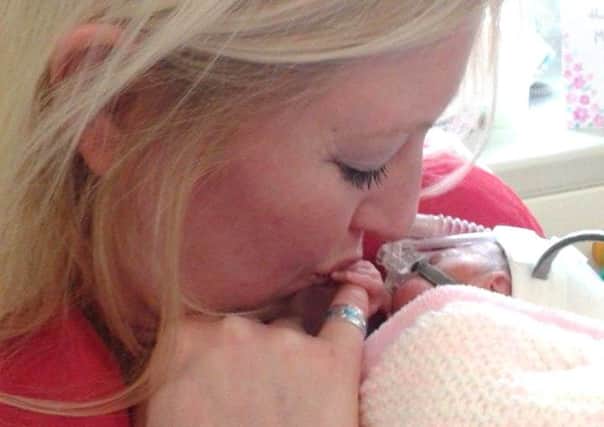 Claire Cressey holding Emily  born at 24 weeks and weighing 1lb 3oz  for the first time. Picture: Deadline