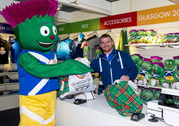 Commonwealth Games silver medalist Peter Kirkbride is all smiles as he and mascot Clyde open the first official Glasgow 2014 retail outlet in the city's Central Station. Picture: SNS