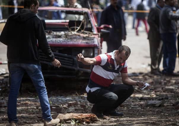 Security staff inspect the scene after bombs struck police posts near Cairo University. Picture: Getty Images