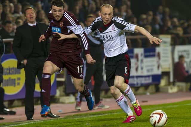 Goalscorer Willo Flood (right) keeps Hearts' David Smith at arms length. Picture: SNS