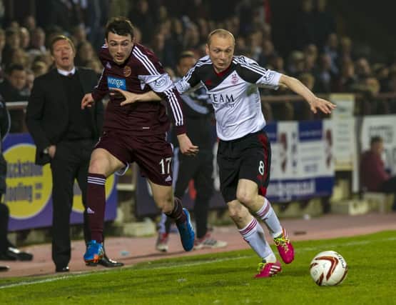 Goalscorer Willo Flood (right) keeps Hearts' David Smith at arms length. Picture: SNS
