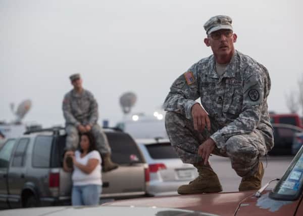 Staff Sgt. John Robertson, right, waits in a parking lot outside of the Fort Hood military base for updates about the shooting that occurred inside on Wednesday. Picture: AP