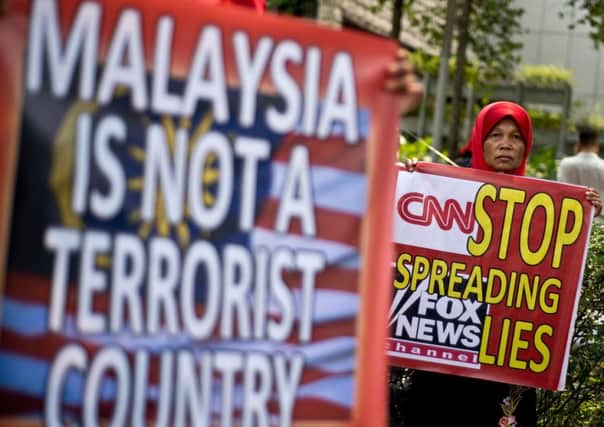 Malaysian activists hold banners during a protest accusing US news channels of unprofessional reporting on missing Malaysia Airlines Flight 370, outside the US embassy in Kuala Lumpur. Picture: AFP/Getty Images