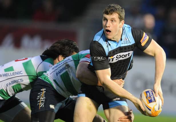 Warriors centre Mark Bennett looks to release the ball as he's tackled. Picture: SNS