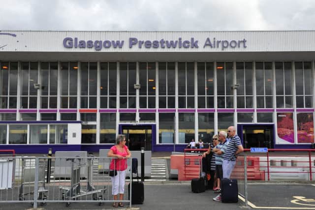 Passengers wait outside Prestwick Airport. Picture: Robert Perry