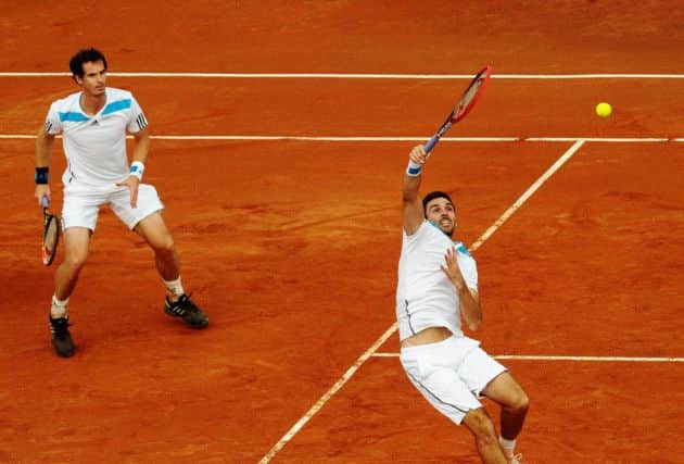 Britains Colin Fleming, right, watched by partner Andy Murray, smashes the ball back during the doubles victory. Photograph: AP