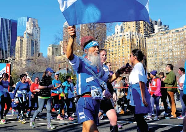 Dressed in Scottish colors and carrying a flag, James Lu crosses the finish line of the Scotland Run, a 10K road race through New York's Central Park. Picture: Getty