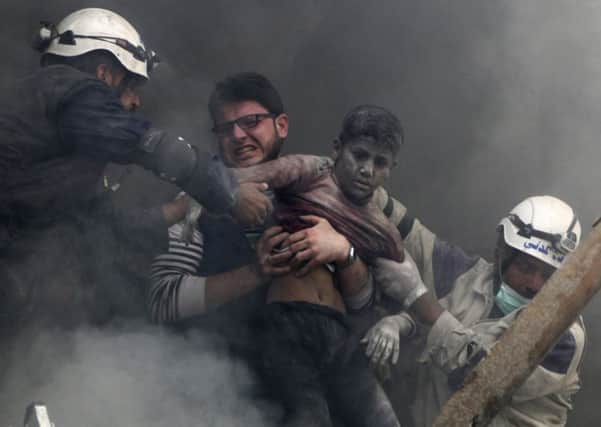 A boy is pulled from a building in Aleppo demolished by barrel bombs.  Picture: Reuters