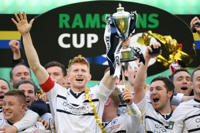 Ratih Rovers captain Jason Thomson celebrates after winning the Ramsdens Cup. Picture: SNS