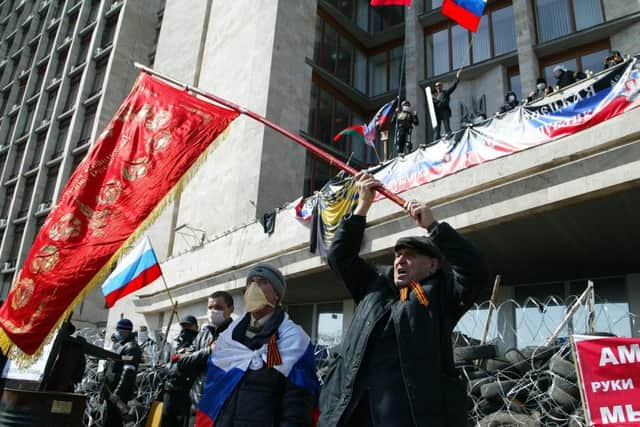 Activists wave an old Soviet flag outside the seized administration building. Picture: AP