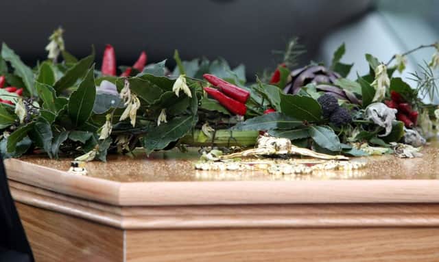 The coffin of Clarissa Dickson Wright is topped with a horned helmet and a wreath made from bay leaves, chillies and artichokes. Picture: Hemedia