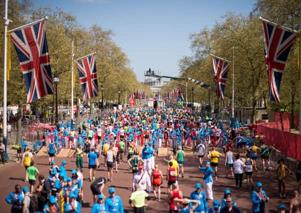 Runners recover after crossing the finish line at The Mall at the end of the London Marathon. Picture: Getty