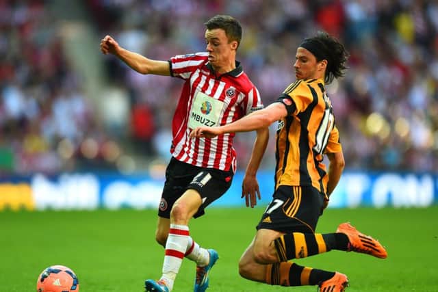 Sheffield Uniteds former Livingston midfielder Stefan Scougall is tackled by Hulls George Boyd. Picture: Getty