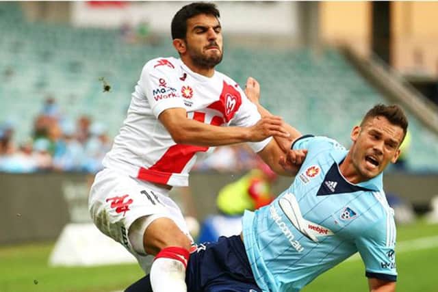 Aziz Behich (Melbourne Heart) tussles with Predrag Bojic (Sydney) during a match between the two sides last year. Picture: Getty