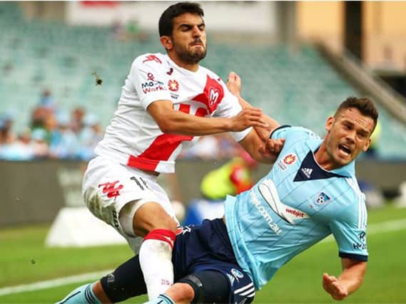 Aziz Behich (Melbourne Heart) tussles with Predrag Bojic (Sydney) during a match between the two sides last year. Picture: Getty