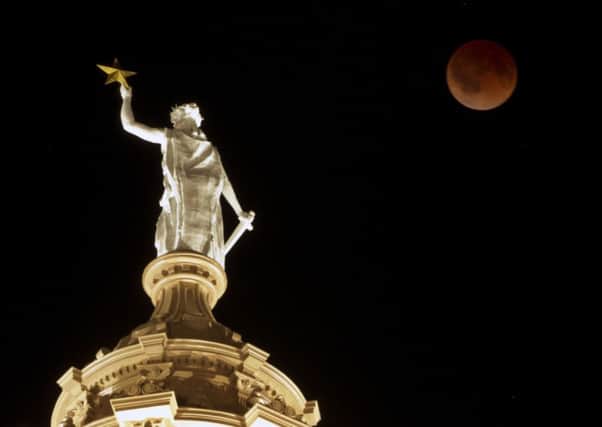 The moon glows a red hue over the Goddess of Liberty statue atop the Capitol in Austin, Texas. Picture: AP
