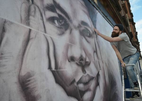 Russell Ian Dempster puts the finishing touches to his mural of Eduardo Paolozzi. Picture: Jon Savage