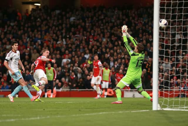 Arsenals Lukas Podolski, left, scores his sides third goal during last nights 3-1 victory. Picture: PA Wire