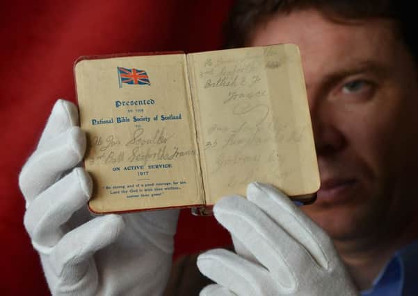 A pocket-sized New Testament bible held by curator Dr Stuart Allan. Picture: Jon Savage