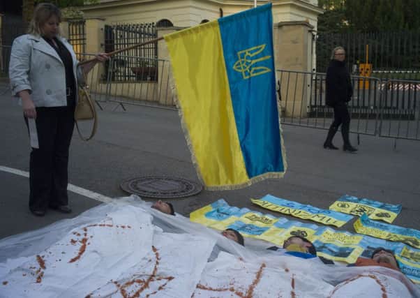 A woman holds the Ukrainian flag next to the protestors laying on the street against Russia's intervention in Ukraine. Picture: Getty