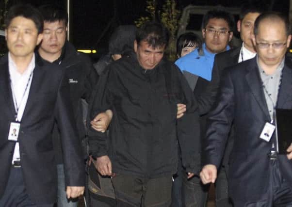 Lee Joon-seok, center, the captain of the sunken ferry, arrives at court south of Seoul. Picture: AP
