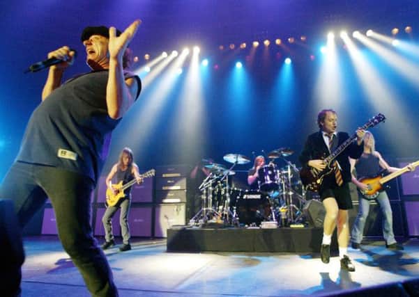 Glasgow-born Malcolm Young, second left, lined up alongside brother Angus, second right, for most of AC/DCs long career. Below left, the fine art of headbanging. Picture: AP