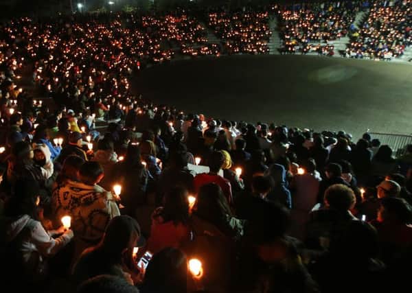 High school students and citizens hold candles and pray for the safe return of passengers. Picture: AP