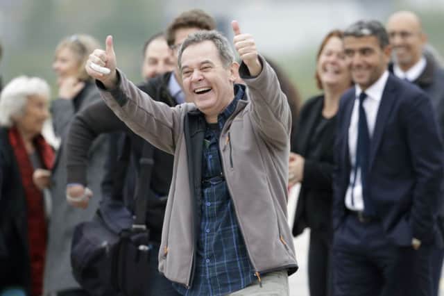 Didier Francois, who was held hostage in Syria for ten months, shows his delight at being back on French soil. Picture: Reuters