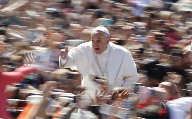 Pope Francis gives the thumbs up as he is driven through the huge crowds at the Vatican yesterday. Picture: Reuters