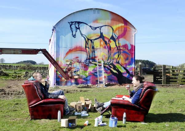 Artists Will Barras and Amy Winstanley take a break from painting an old barn at East Knockbrex Farm, near Newton Stewart. Picture: Colin Hattersley
