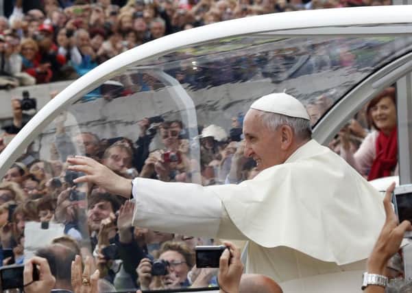 Pope Francis waves to the faithful as he is driven through the crowd in Via della Conciliazione. Picture: AP