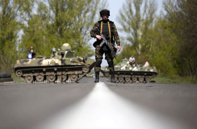 A Ukrainian soldier plus armoured carriers make for a formidable checkpoint at Malinivka, in eastern Ukraine. Picture: Reuters