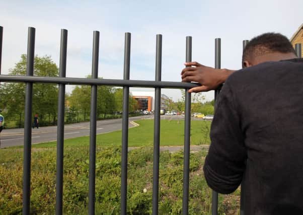 A boy with his head against railings outside Corpus Christi Catholic College, Leeds, where a teacher was stabbed to death. Picture: PA