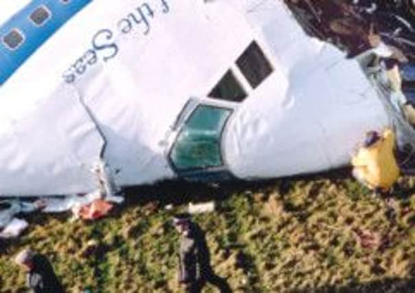 Investigators look at the wreckage of the cockpit section of Flight 103. Picture: Bryn Colton