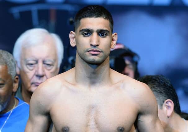 Boxer Amir Khan poses on the scale during his official weigh-in at the MGM Grand Garden Arena on May 2, 2014 in Las Vegas, Nevada. Khan will meet Luis Collazo in a welterweight bout on May 3. Picture: Getty
