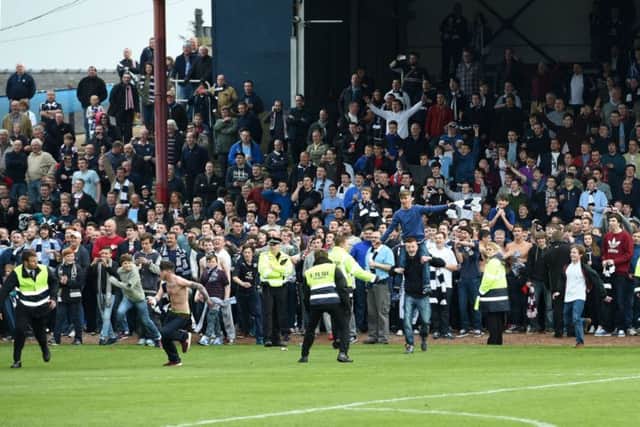 Dundee fans invade the pitch after securing promotion to the Scottish Premiership. Picture: SNS
