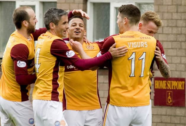 03/05/14 SCOTTISH PREMIERSHIP
MOTHERWELL v ST JOHNSTONE
FIR PARK - MOTHERWELL
Motherwell's Lionel Ainsworth (third from left) is swarmed by teammates after his goal.