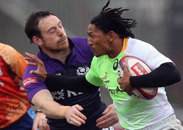 Justin Geduld of South Africa is tackled by Scott Riddell during day two of the IRB Glasgow Sevens. Picture: Getty
