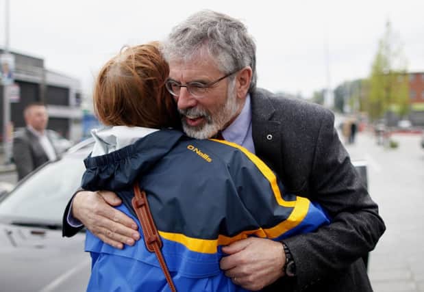 Gerry Adams gets a warm welcome from a woman on the Andersonstown Road in West Belfast yesterday. Picture: AP